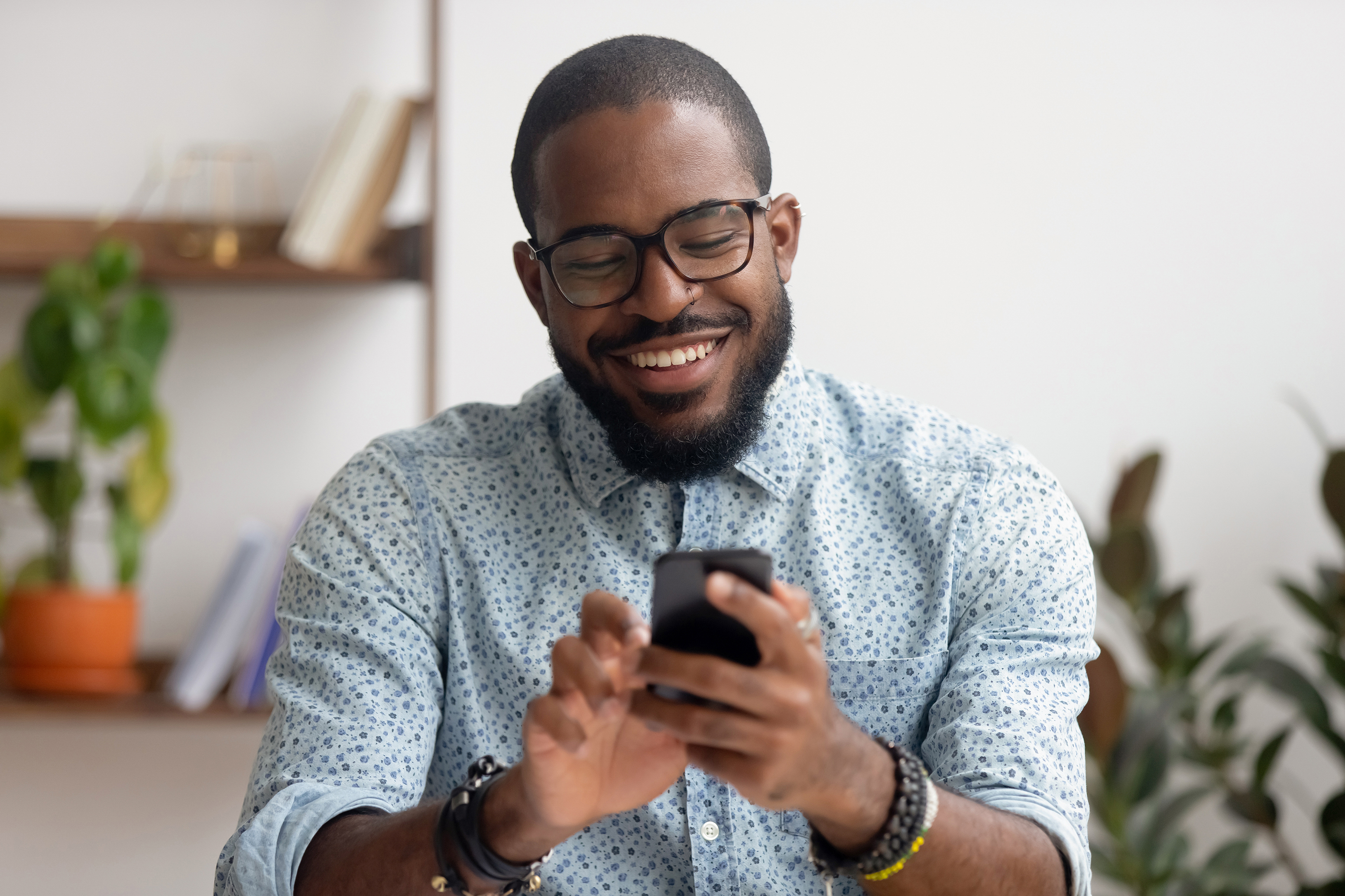 a man smiles at a phone in his hand